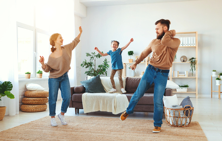 happy family mother father and child daughter dancing at home