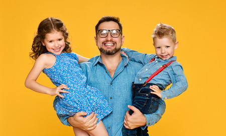 Happy father's day! Children daughter and son congratulates dad  on yellow backgroundの写真素材
