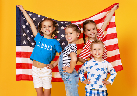 group of children with flag of the United States of America USA on yellow color backgroundの写真素材