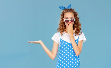 young beautiful funny girl on colored blue backgroundの写真素材