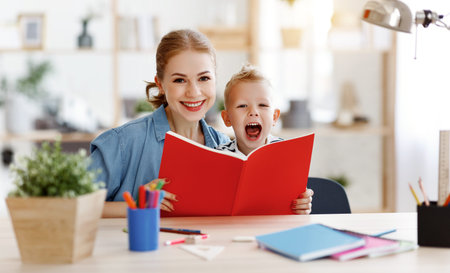 mother and child son doing homework writing and reading at home