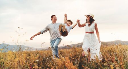 Happy family father of mother and child son  on nature at sunsetの写真素材