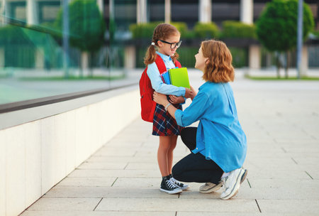 first day at school. father leads a little child school girl in gradeの写真素材