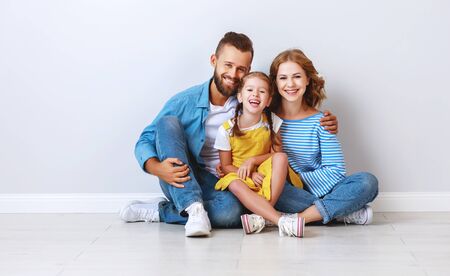 happy family mother father and child daughter near an empty brick wallの写真素材