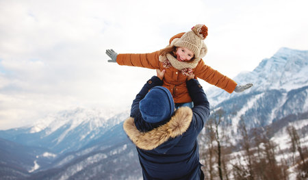 happy family father and child daughter playing and hugging  on a winter walk