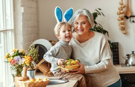 Happy easter! family grandmother and child grandson with ears hare getting ready for holidayの写真素材