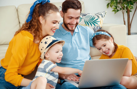 Happy family: smiling handsome male with woman and kids gathering at sofa in living room all...