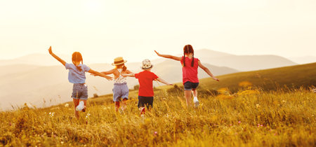 Unrecognizable cheerful little girls in casual clothes having fun and running back in together in...