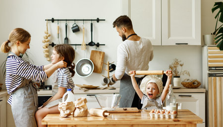 Cheerful parents and little kids preparing ingredients and utensils for baking while enjoying time together in home kitchenの写真素材
