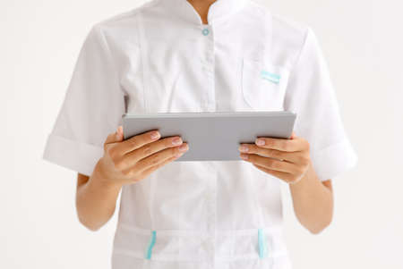 medical concept. cropped unrecognizable doctor holding a tablet wireless computer on a white backgroundの写真素材