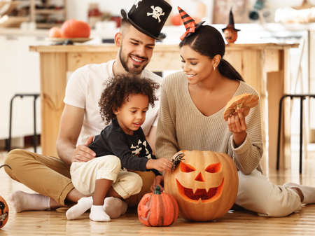 happy multiethnic family mother, father and little son have fun and celebrate Halloween at homeの写真素材