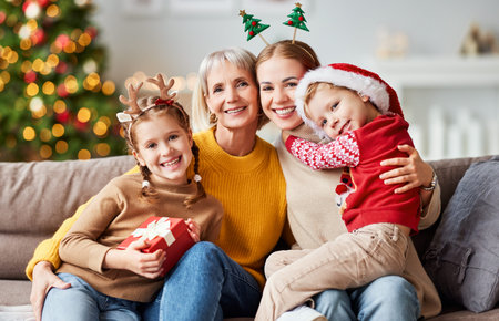 happy multi generation family grandmother, mother and children give each other gifts, hug and smile looking at the camera during the celebration of Christmas and new yearの写真素材