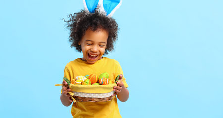 Adorable happy little African American boy with curly hair in casual clothes and bunny ears on head...