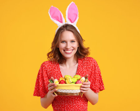 Cheerful young female in casual red clothes and bunny ears on head smiling and looking at camera...