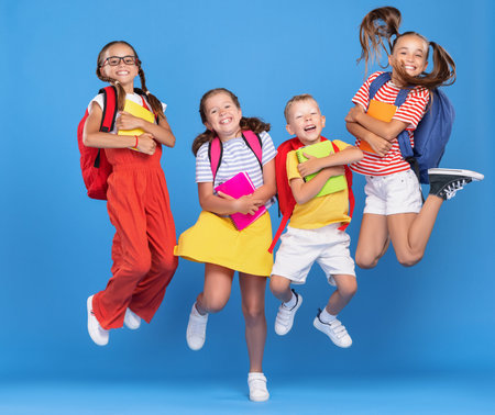 Group of funny excited classmates girls and boys with multicolored backpacks and copybooks having...