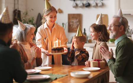Happy big family gathered in living room table to celebrate birthday of cute little boy, excited...