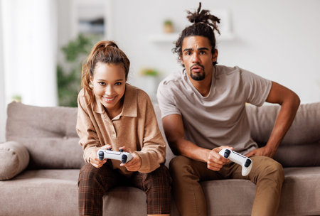 African american couple laugh and play video games together using a video game console
