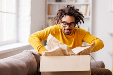 African American man cheering about delivered parcelの写真素材