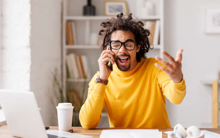 Emotional African American businessman making phone callの写真素材