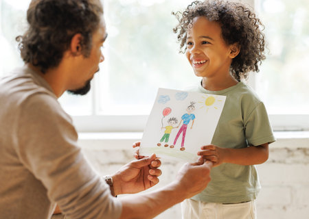Cute little african american boy son congratulating dad with Fathers Day at home