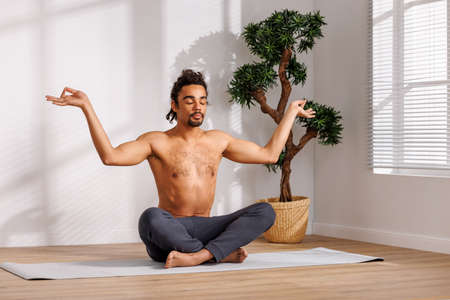 Calm African American man meditating in morningの写真素材