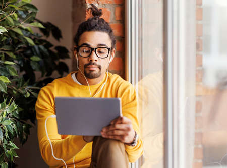 Calm black freelancer using tabletの写真素材