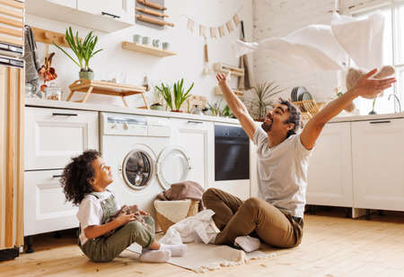 Excited father and kid playing with towelsの写真素材