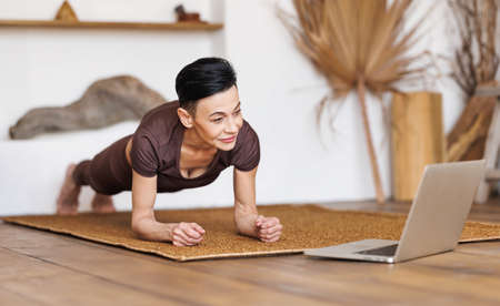 Mature woman exercising in morning at homeの写真素材