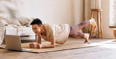 Mature woman exercising in morning at homeの写真素材
