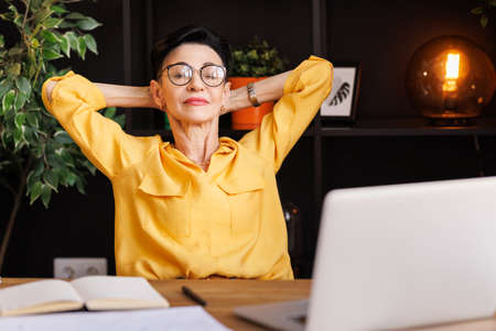 Stylish businesswoman taking break in work in home officeの写真素材