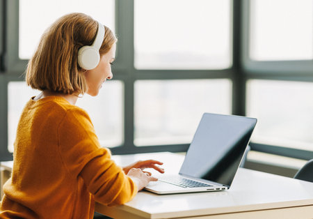 Happy young female having video call while working remotely or studying online on laptop from home