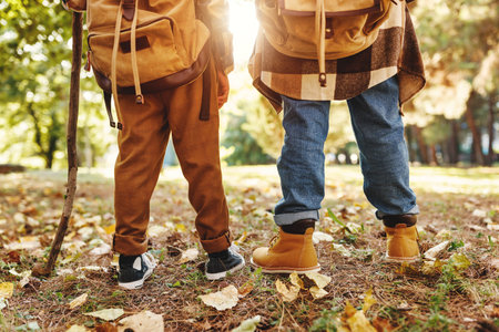 little travelers. legs of two children with backpacks in summer in forestの写真素材