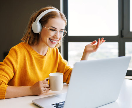 Positive young businesswoman speaking to online colleaguesの写真素材