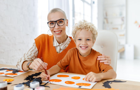 Young family mother and child preparing decorations for Halloween and engage in creativityの写真素材