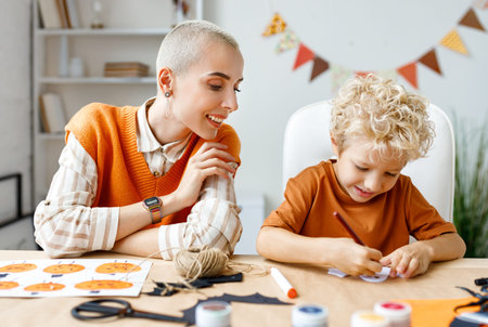 Young family mother and child preparing decorations for Halloween and engage in creativityの写真素材