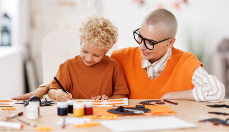 Young family mother and child preparing decorations for Halloween and engage in creativityの写真素材