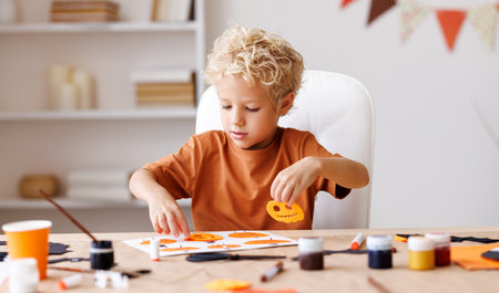 Cute child boy making Halloween home decorationsの写真素材
