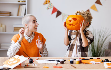 Young family mother and child preparing decorations for Halloween and engage in creativityの写真素材