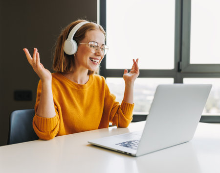 Positive young businesswoman speaking to online colleaguesの写真素材