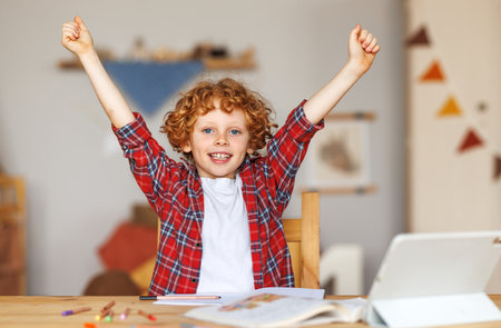 with excitement during home distance education on laptop computer, kid celebrating finishing homeworkの写真素材