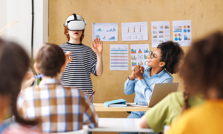 Innovation in education. Student schoolboy in virtual reality glasses together with teacher during lesson in bright classroom at schoolの写真素材