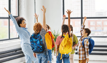 Group of schoolchildren and teacher standing together, celebrate successful completion of collective...