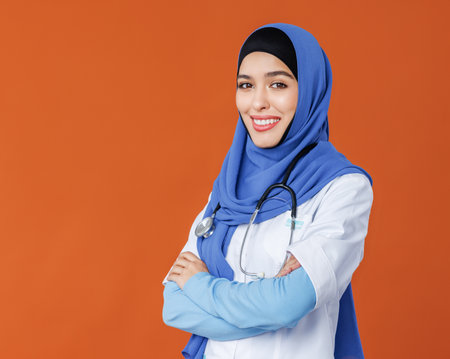 Professional woman doctor in muslim national hijab isolated on orange backgroundの写真素材