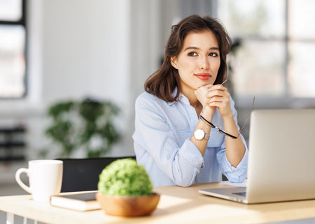beautiful young smiling woman working remotely behind a laptop at homeの写真素材