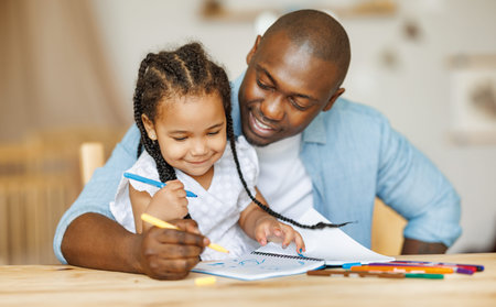 Teaching children. Happy african american family father painting together with cute daughterの写真素材