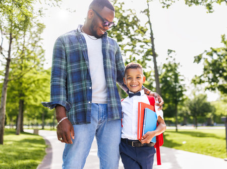 Joyful african american boy hugging dad after school lessonsの写真素材