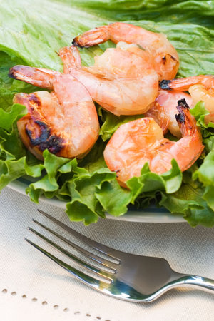 Grilled shrimps on plate served with green romano salad are ready to eatの写真素材