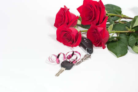 Beautiful scarlet roses bouquet and car keys as a Valentine day giftの写真素材
