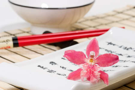 Sushi set on bamboo  place mat  and red orchids flower on small plateの写真素材