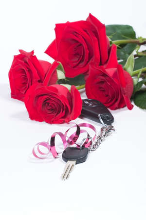 Beautiful scarlet roses bouquet and car keys as a Valentine day gift over white paper background. includes copyspace.の写真素材